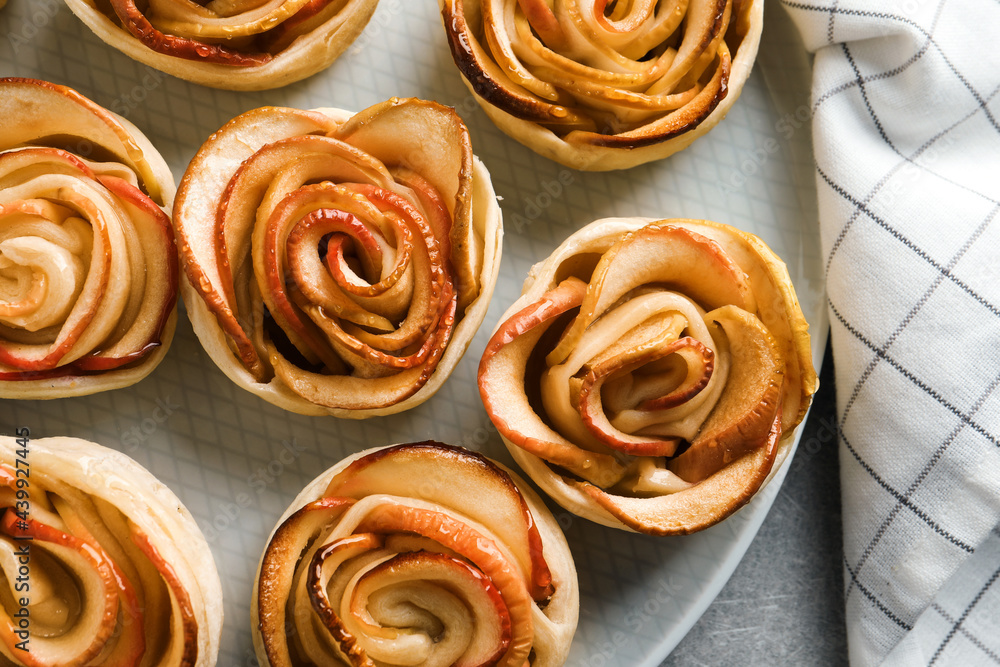 Freshly baked apple roses on grey table, flat lay. Beautiful dessert Freshly baked apple roses on grey table, flat lay. Beautiful dessert