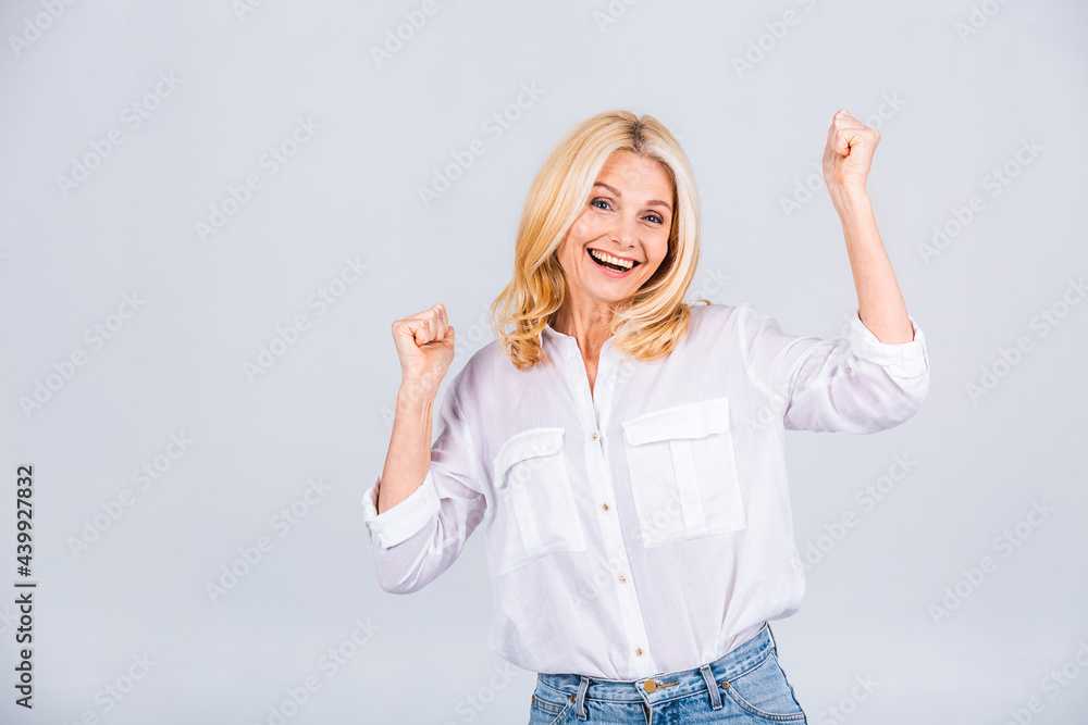 I'm winner! Portrait of a cheerful happy senior mature woman gesturing victory isolated over white grey background. I'm winner! Portrait of a cheerful happy senior mature woman gesturing victory isolated over white grey background.