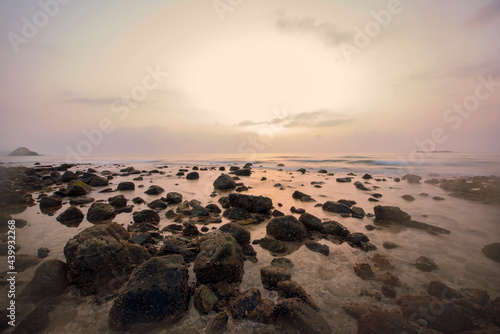 Beautiful Sunrise at Beach with lots of rocks and Slow shutterspeed on water with sun visible. Costal Area , nature photography