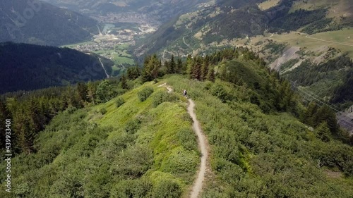 Mountain biker on trail in alps aerial flight - 4k UHD