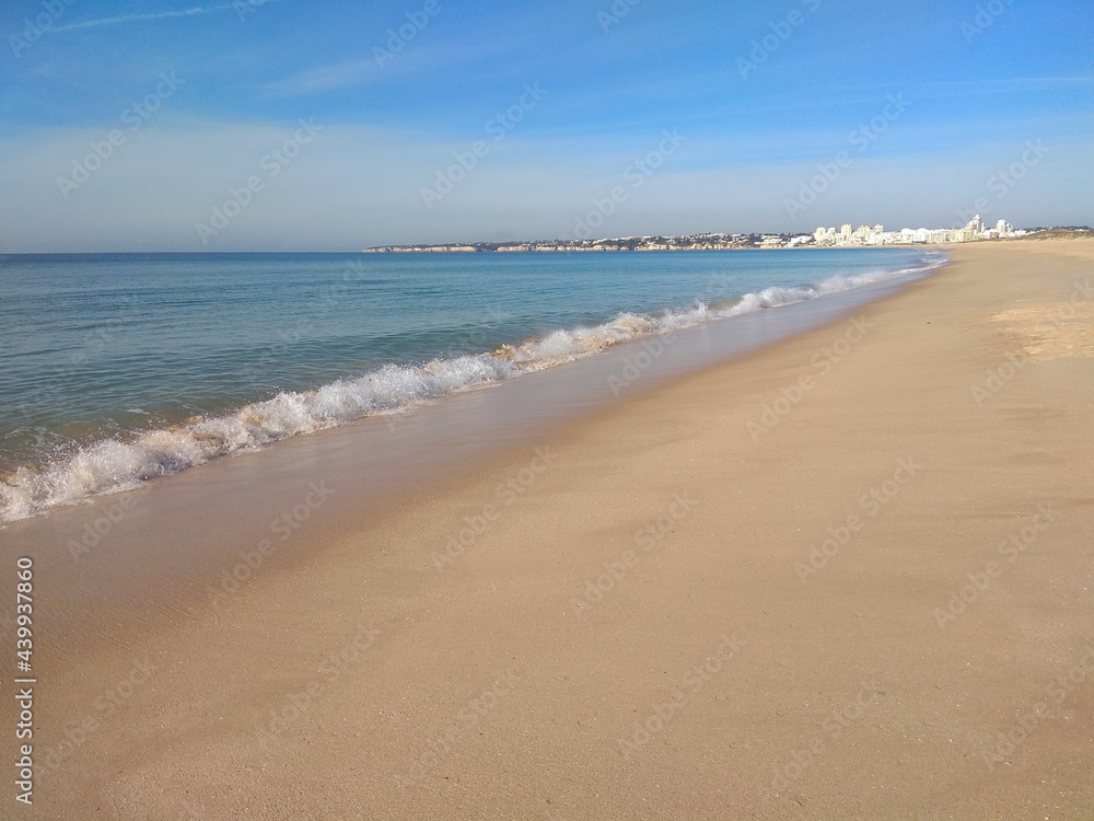 Ocean beach. Sea water, ocean with white foam on waves. Beige color sand. Blue sly. Sea beach photo
