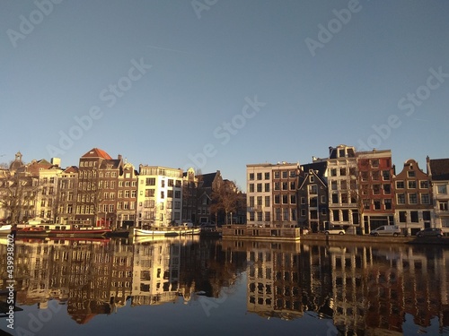 Amsterdam houses urban city view. Building near the water. Amsterdam houses bright daytime photos