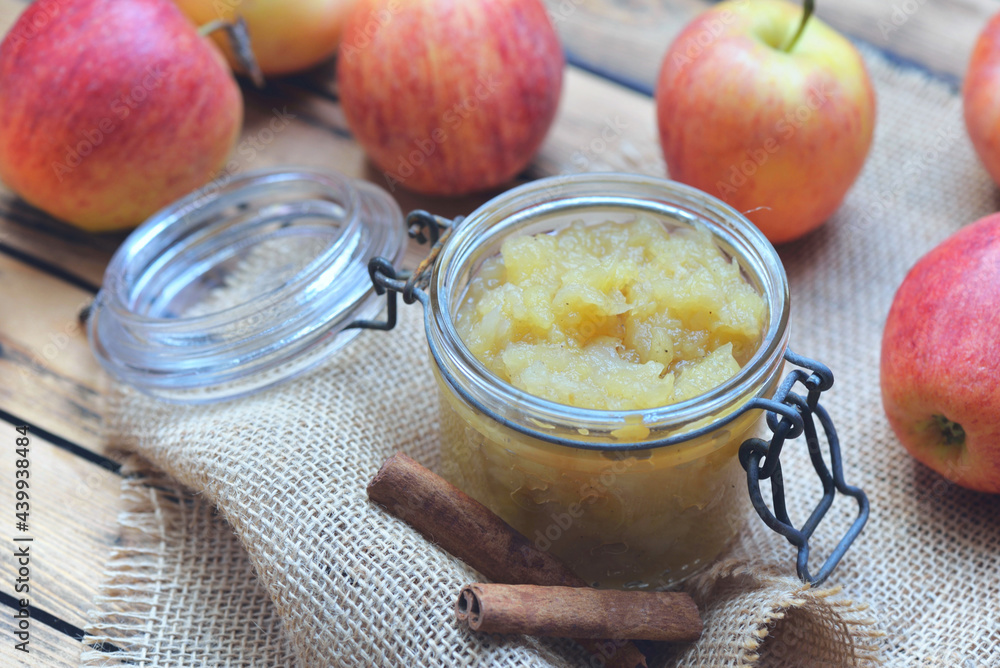 homemade compote in a glass jar with red apples and cinnamon on a wooden table homemade compote in a glass jar with red apples and cinnamon on a wooden table