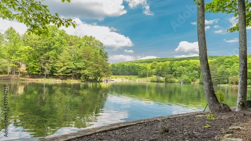 Scenic panorama of Lake Dartmoor in Tennessee shows a very calm, glassy lake surface with rich, healthy oak trees lining the shoreline.