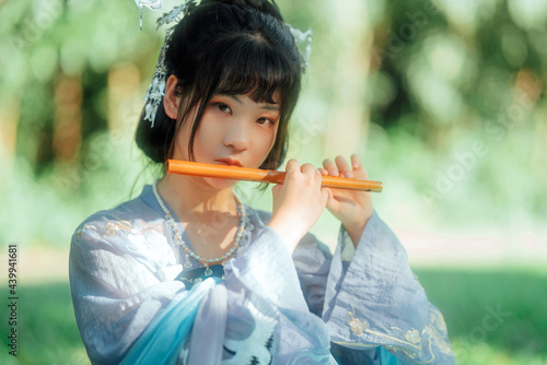 Asian teenage girl playing bamboo flute photo