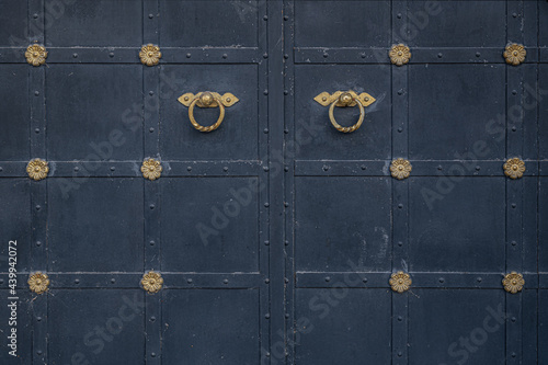 old dark grey metal gate with beautiful gild decor
