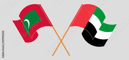 Crossed and waving flags of Maldives and the United Arab Emirates