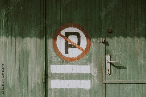prohibited sign parking on the wooden wall of a shop, no parking sign