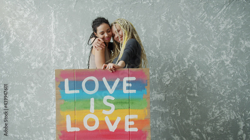 Photography Female lesbian couple holding colorful LGBT poster