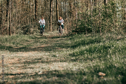 Two female Mathure friends are riding bicycle bicycles through the forest. Active lifestyle  hobby