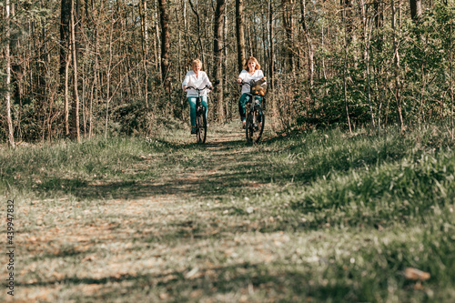 Two female Mathure friends are riding bicycle bicycles through the forest. Active lifestyle, hobby