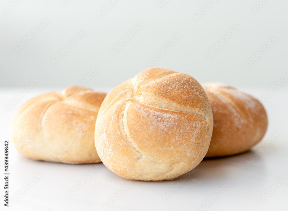 three fresh Kaiser rolls on a table