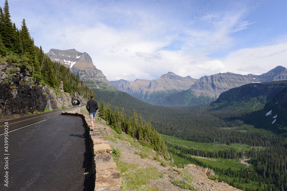 Man walking along the side of the Going to the Sun Road in Glacier National Park in Montana