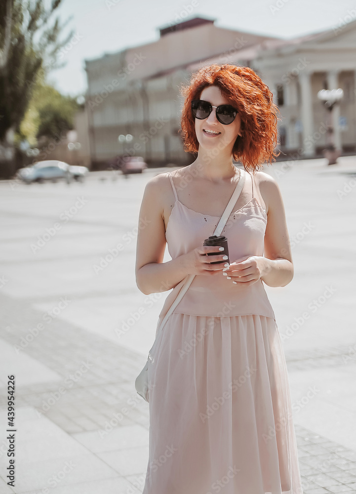 Naklejka premium woman in a city drinks coffee