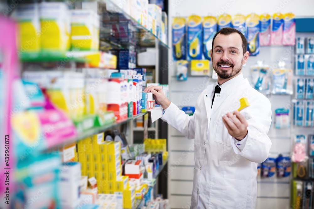 Smiling male offer right drug in pharmacy