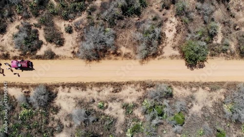 Camper Vans And Travelers On The Desert Road At Tsingy de Bemaraha National Park, Melaky, Madagascar. aerial drone sideways photo