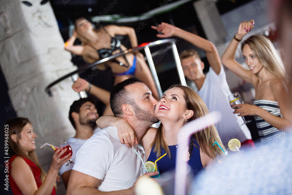 Obraz premium Happy cheerful man and woman dancing and hugging on party in the club