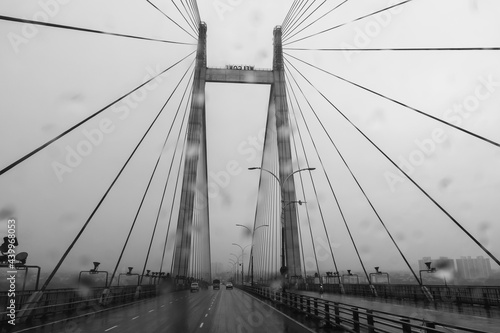 Vidyasagar Setu over river Ganges, known as 2nd Hooghly Bridge in Kolkata,West Bengal, India. Abstract black and white image shot aginst glass with raindrops all over it, monsoon image of Kolkata.