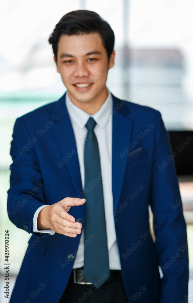 Cheerful Asian businessman reaching out hand for handshake Cheerful Asian businessman reaching out hand for handshake