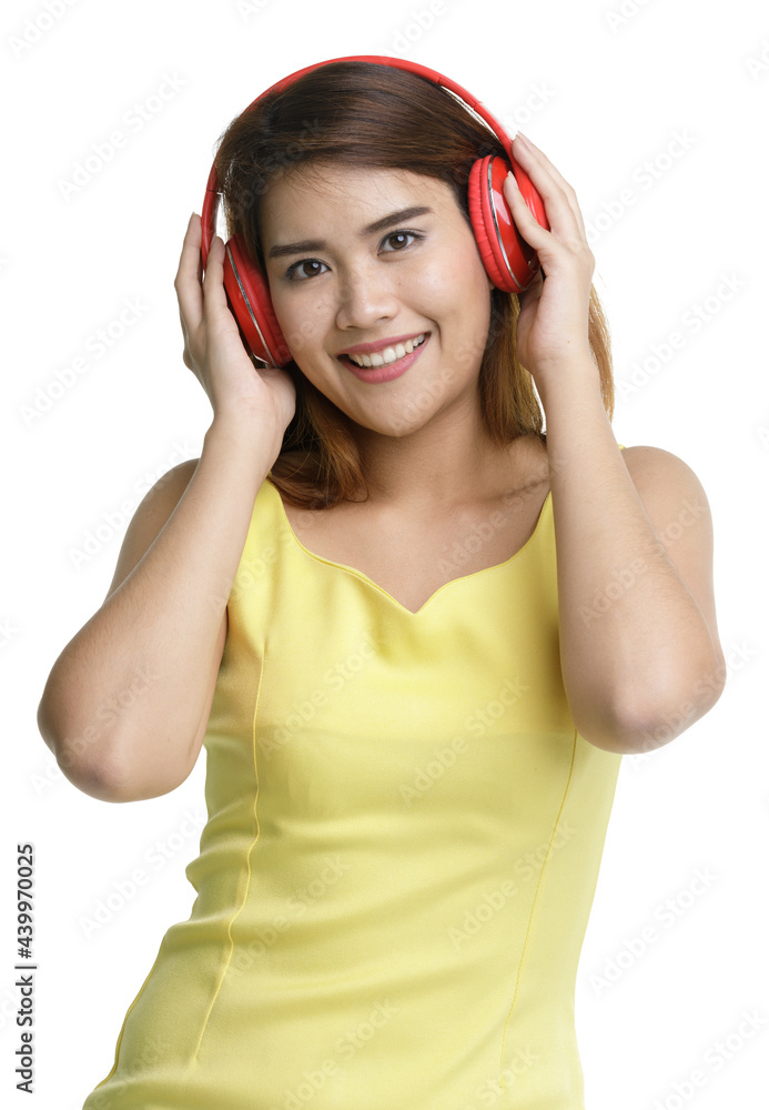 Isolated portrait close up shot of Asian happy female teenager wear large red headphones stand listening to music and dancing Isolated portrait close up shot of Asian happy female teenager wear large red headphones stand listening to music and dancing