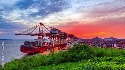 Container ship loading and unloading in deep sea port,business logistic import and export freight transportation by container ship.Busy container port at sunset.industrial scene,4k time lapse. photo