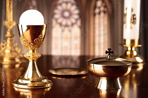 First Holy Communion. Catholic religion theme. Crucifix, the Cross and Golden chalice and wafer on the altar in the church. photo