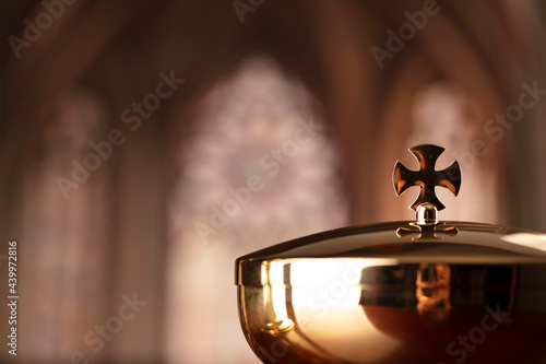 First Holy Communion. Catholic religion theme. Crucifix, the Cross and Golden chalice and wafer on the altar in the church. photo