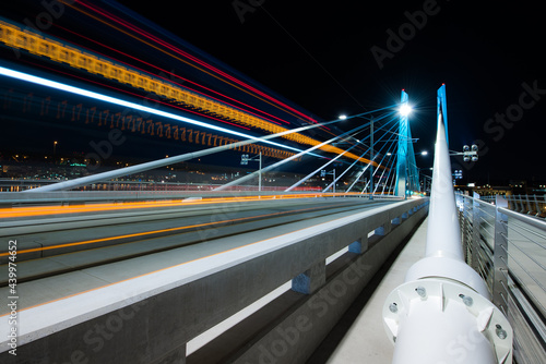 Light trails from a passing train at night on Tilikum Crossing Bridge in Portland, Oregon photo