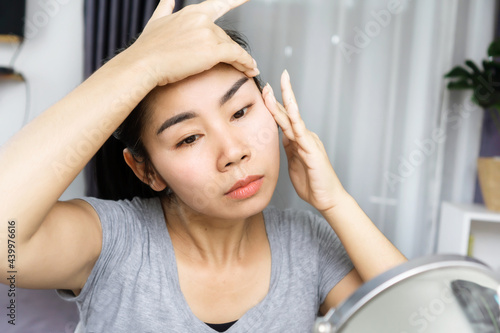 Asian woman age 40s doing facial massage , using fingers lifting her face for anti aging ,wrinkle on skin photo