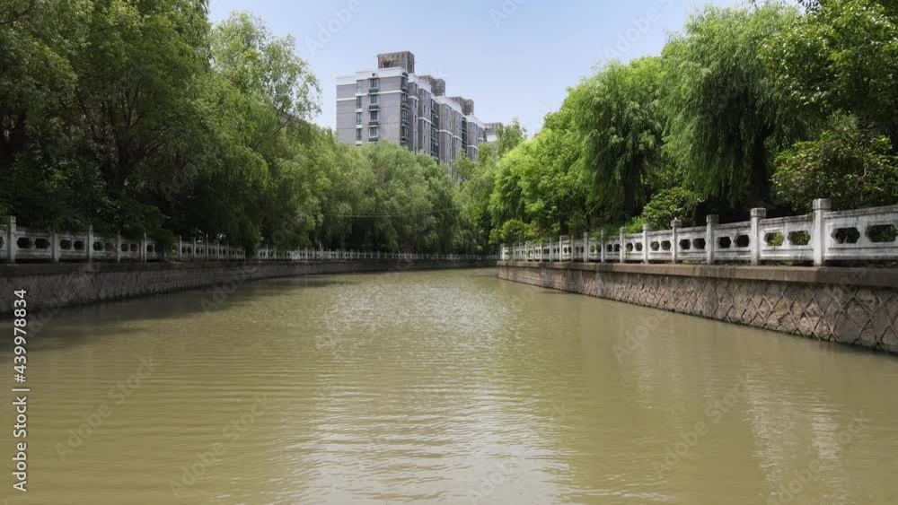 Drone flying over the river with traditional Chinese decoration. No people view. Tourism, travel or culture concept b-roll footage in Shanghai China, drone aerial view of calm water front and trees Drone flying over the river with traditional Chinese decoration. No people view. Tourism, travel or culture concept b-roll footage in Shanghai China, drone aerial view of calm water front and trees