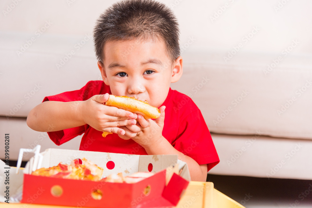 Hot Homemade, Vegetarian fast Italian food, Cute Little Child enjoying eating Delivery Pizza pepperoni, cheese many slices deliciously in an open cardboard box at home Hot Homemade, Vegetarian fast Italian food, Cute Little Child enjoying eating Delivery Pizza pepperoni, cheese many slices deliciously in an open cardboard box at home