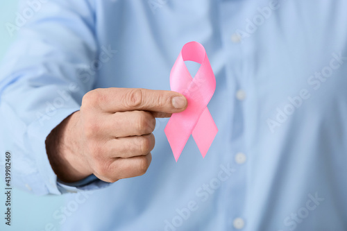 Man with pink ribbon, closeup. Breast cancer awareness concept