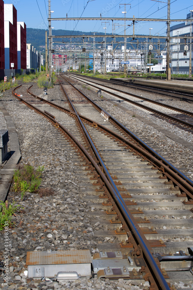 Fototapeta premium Close-up of railway switch st train station Zurich Schlieren at a beautiful summer day. Photo taken June 15th, 2021, Schlieren, Switzerland.