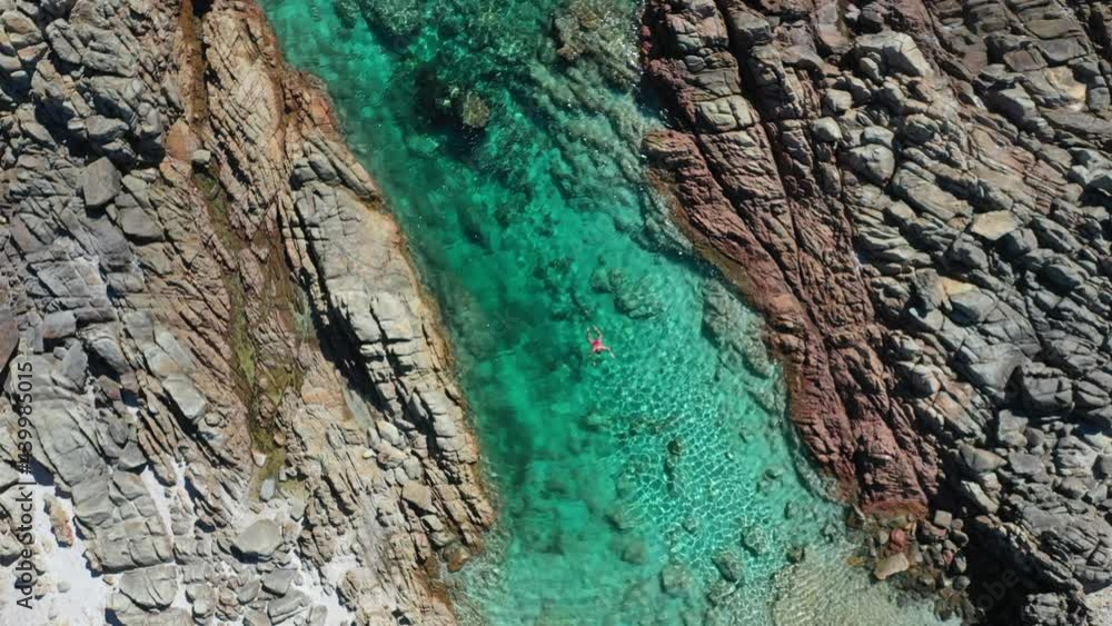 Lonely Woman Snorkeling in Turquoise Lagoon Water Ascending Top Down Drone Shot. The Aquarium, Cape Naturaliste, Australia Lonely Woman Snorkeling in Turquoise Lagoon Water Ascending Top Down Drone Shot. The Aquarium, Cape Naturaliste, Australia