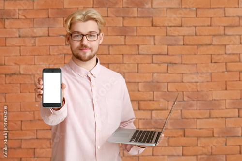 Handsome man with laptop an...
