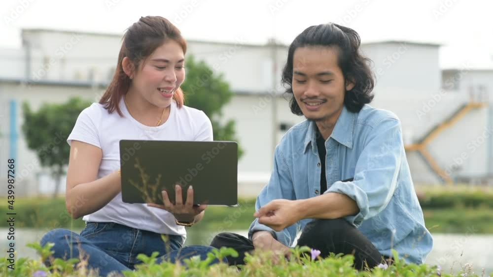 Asian people sitting outdoor using computer city park Asian people sitting outdoor using computer city park