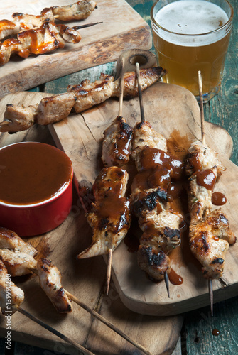 Pork skewers served with BBQ sauce and beer photo