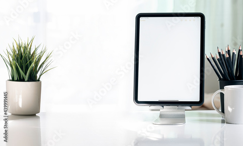 Mockup blank screen tablet in vertical view on white table with copy space.