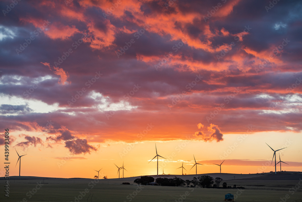 wind turbines in farmland against sunset sky wind turbines in farmland against sunset sky