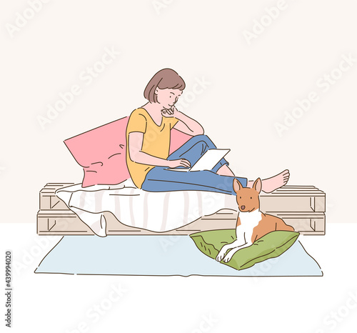 A woman is reading a book on her bed and a dog is sitting under it. hand drawn style vector design illustrations. 