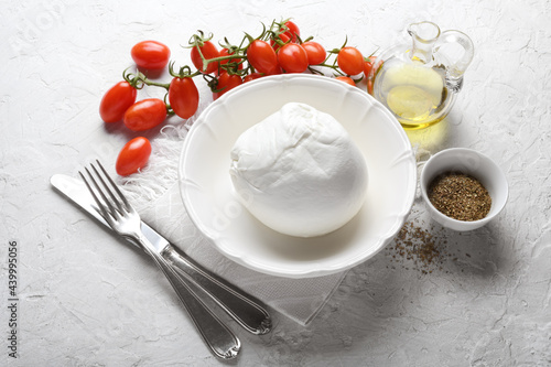 Buffalo mozzarella, cherry tomatoes, extra virgin olive oil and oregano on white plaster background. photo