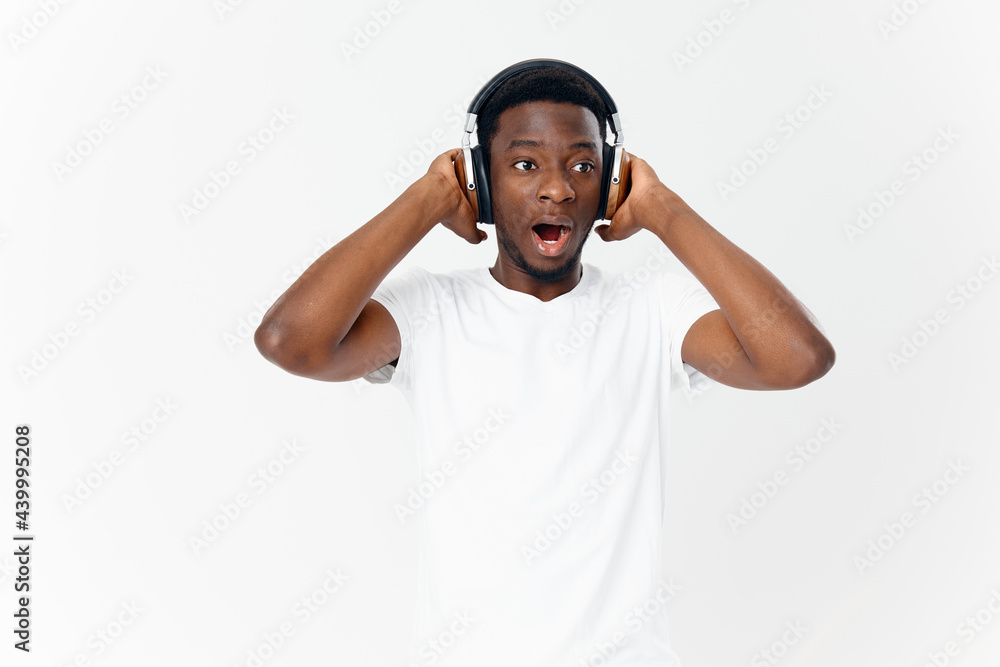 man of african appearance in headphones in a white t-shirt listening to music entertainment man of african appearance in headphones in a white t-shirt listening to music entertainment