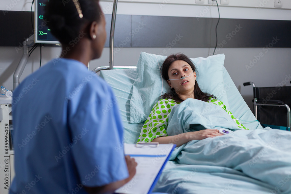Black afro-american asisstant discussing with patient monitoring ...