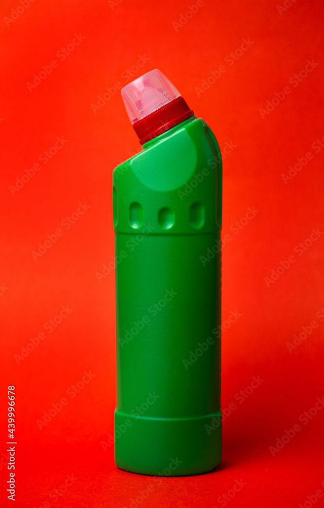 green bottle with cleaning agent on a red background green bottle with cleaning agent on a red background