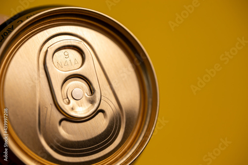 key on a metal beer can on a yellow background
