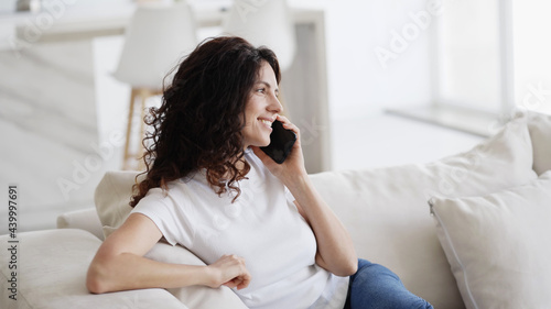 Woman with mobile phone home, beautiful brunette young happy model using smartphone © Utkamandarinka