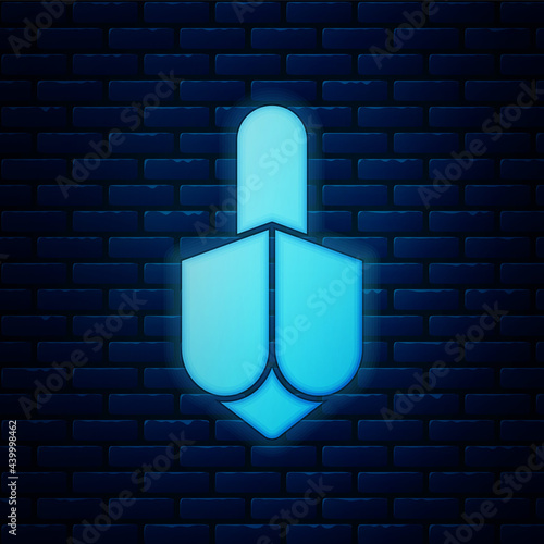 Glowing neon Hanukkah dreidel icon isolated on brick wall background. Vector photo