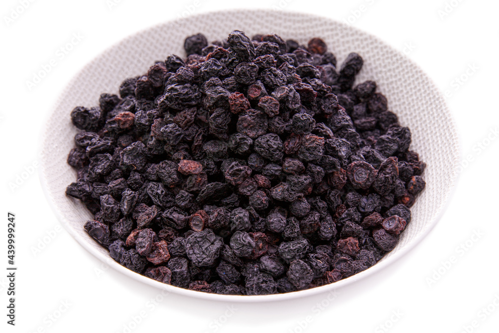 Dried blueberries in a white dish on a white background.Isolated products and items Dried blueberries in a white dish on a white background.Isolated products and items