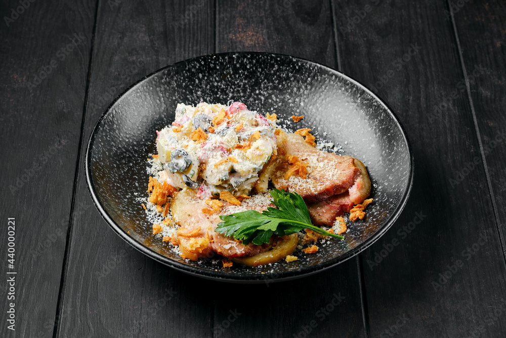 Fried ham with salad sprinkled with bacon chips and grated parmesan