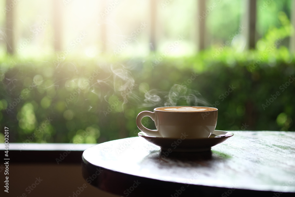 Hot coffee on a wooden table on the terrace.